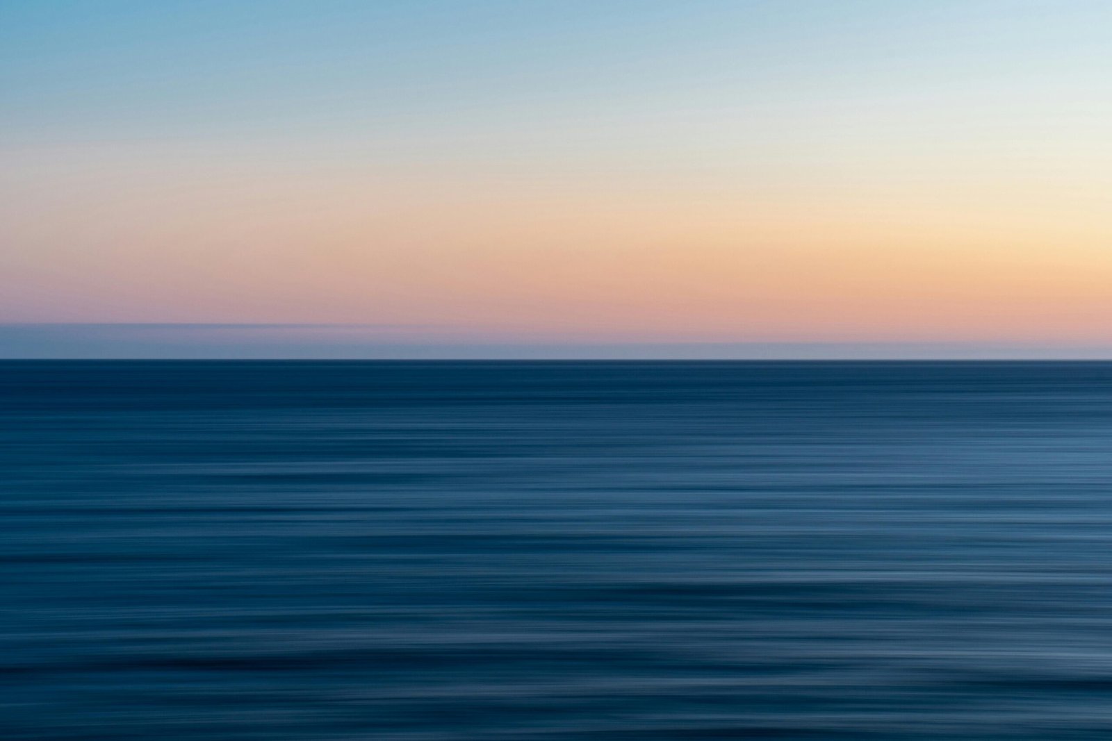 Serene ocean scene with a beautiful gradient sunset sky over calm waters.